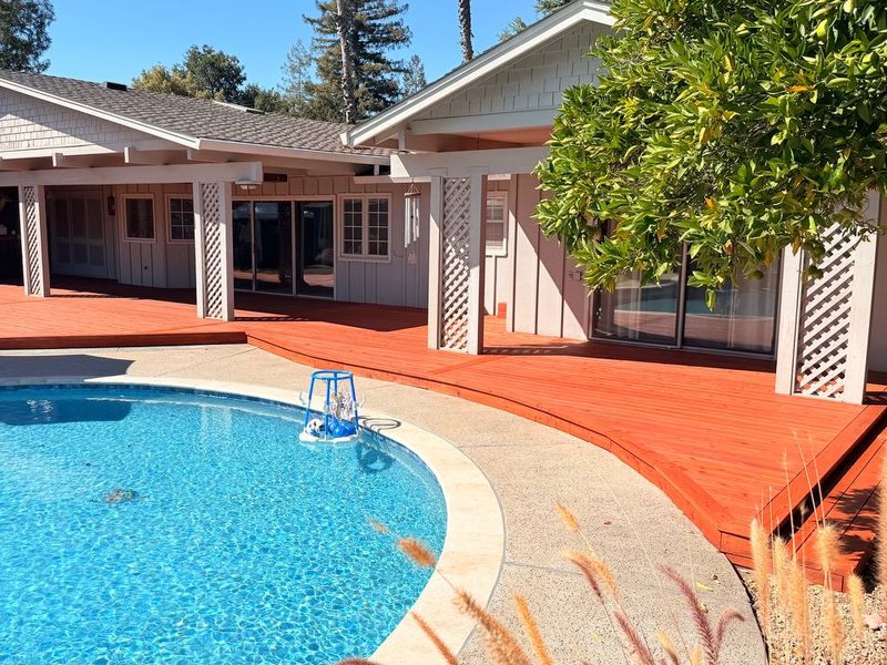 Redwood deck along the back of a Los Altos house, next to the pool
