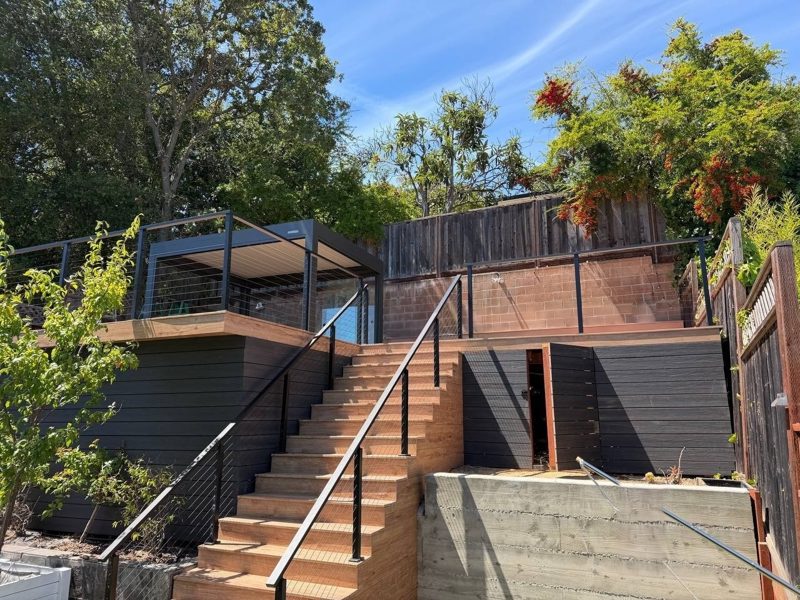 Hillside deck in Eva-Last Pioneer Barrel Oak with a staircase down to the lawn and aluminum cable railing, San Carlos